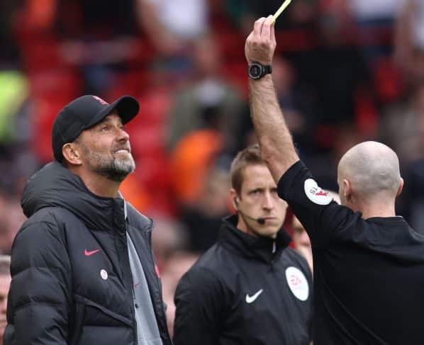 Jurgen Klopp receives a yellow card during Liverpool's win over Tottenham.